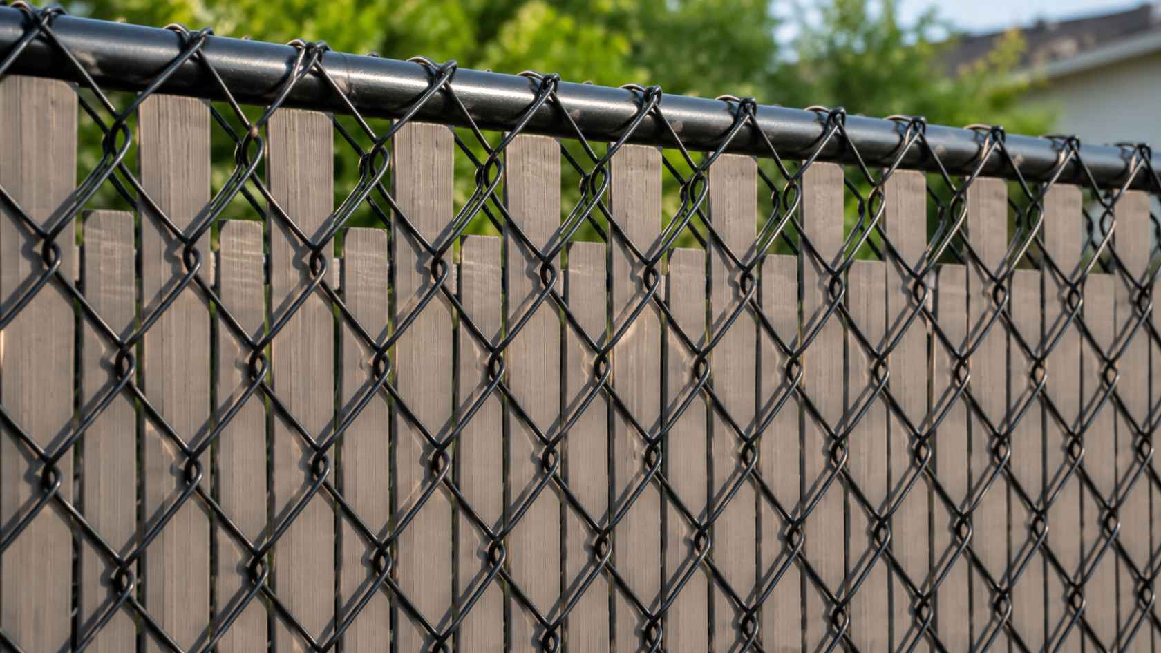 Chain-link fence with privacy slats creating a modern backyard screen