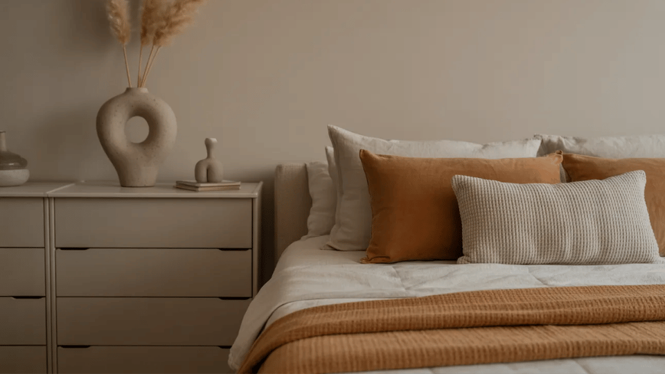 Minimalist bedroom with ceramic accents and warm neutral decor.
