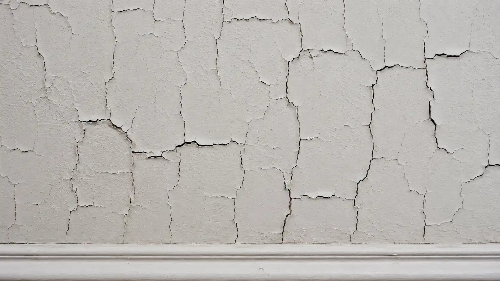 Cracks in the paint on aged wall.