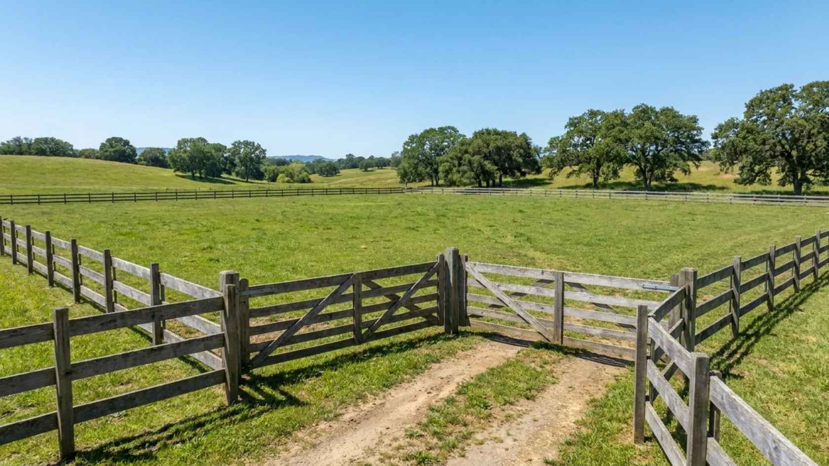 Post and rail wood fence defining a large property while keeping the landscape open.