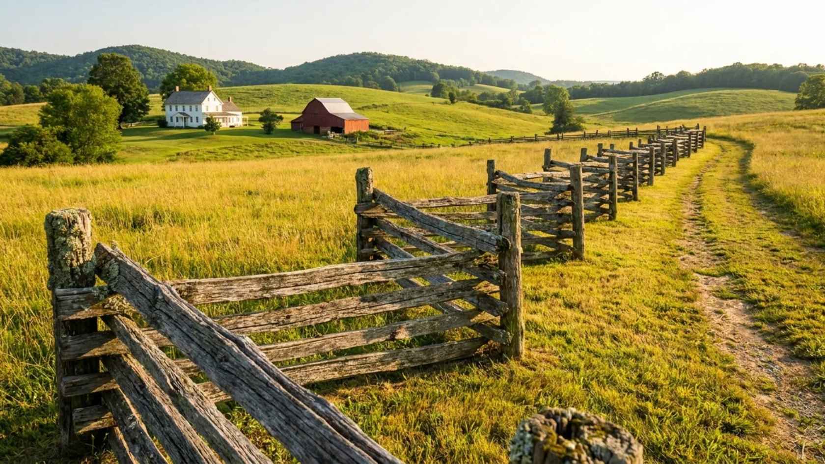 Rustic split rail fence across an open field with countryside views and natural wood rails.