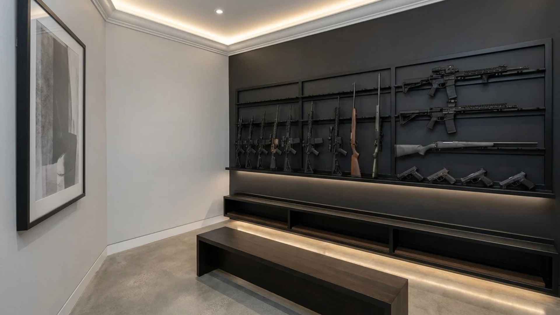 Wall-mounted gun racks displaying rifles and pistols on a dark accent wall in a clean organized room