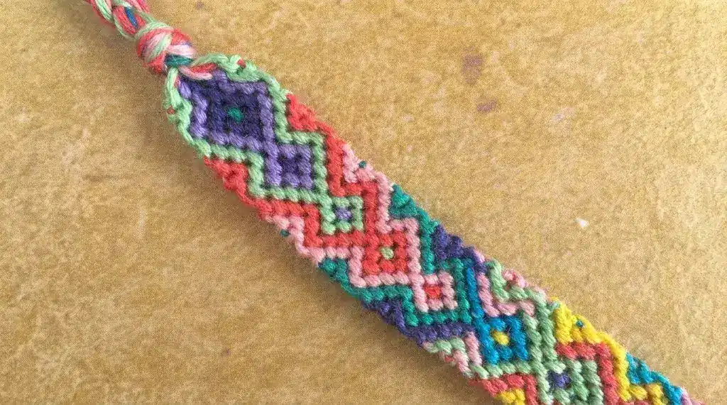 A woven friendship bracelet with colorful geometric diamond patterns