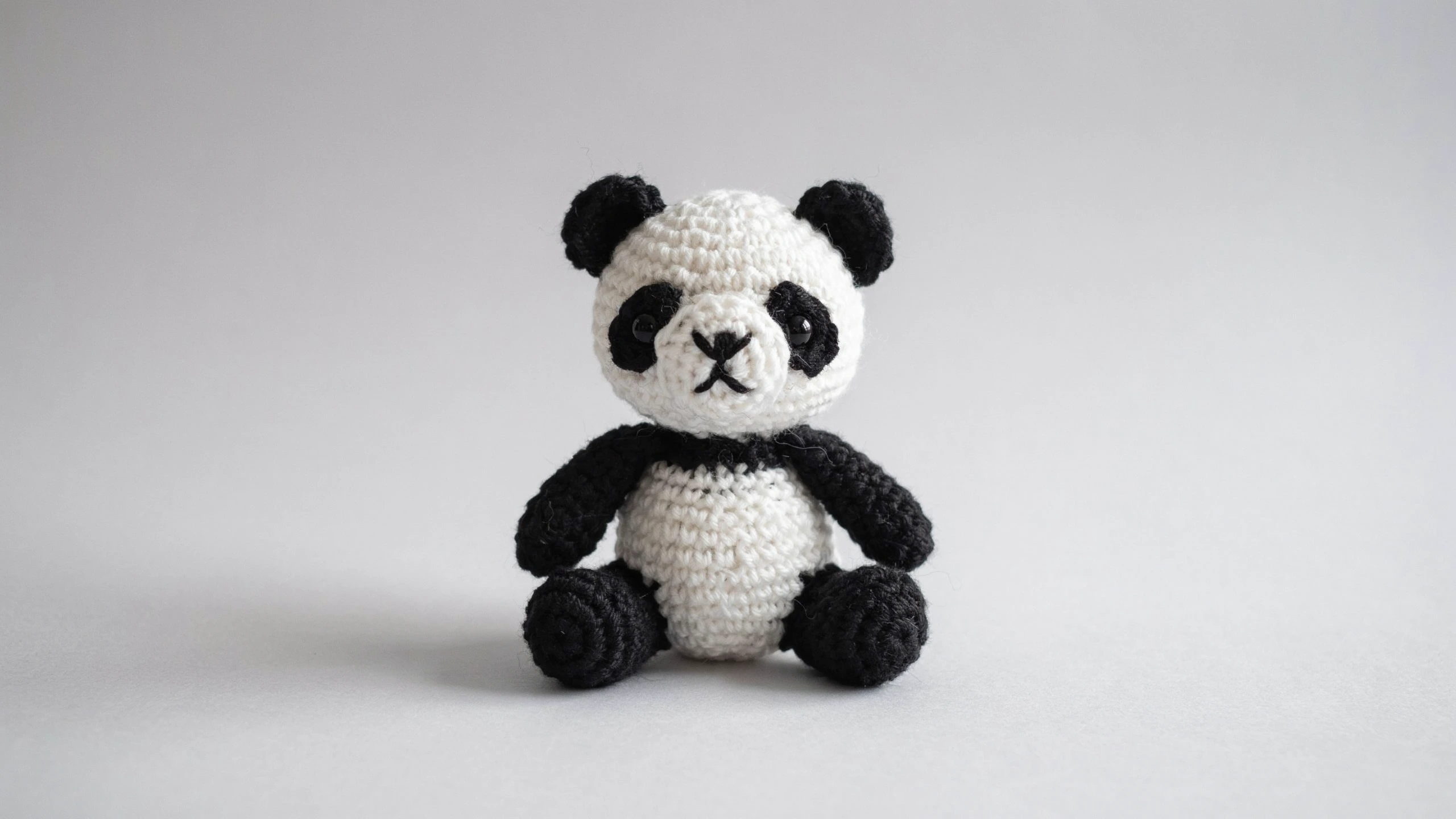 Black and white crochet panda with eye patches centered