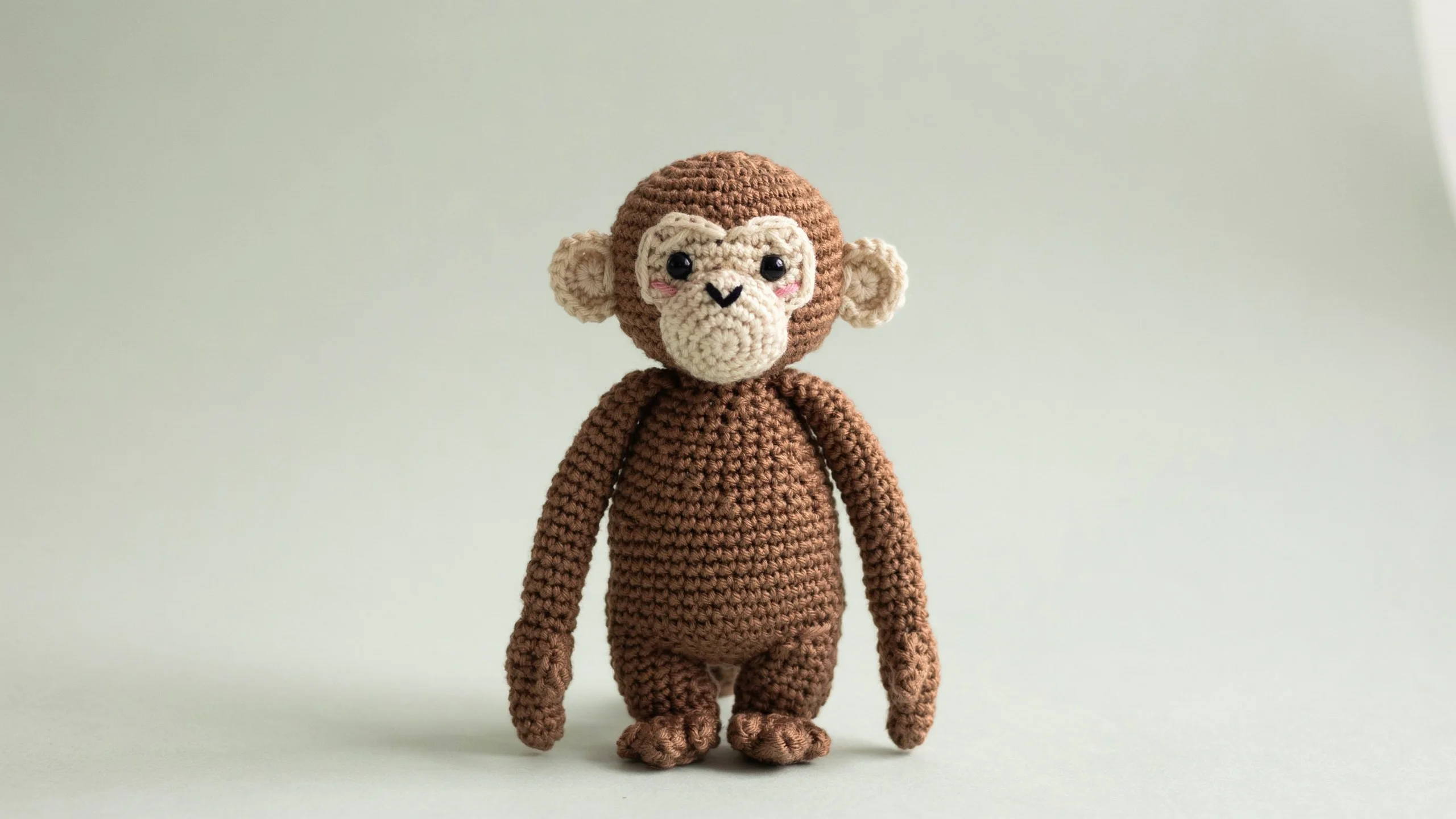 Brown crochet monkey with long arms and light face panel centered