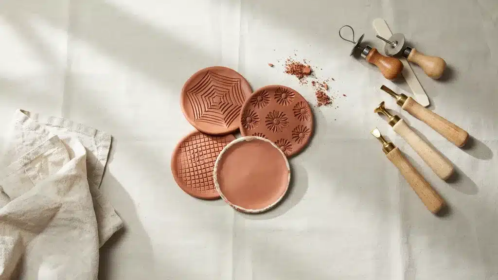 Set of handmade clay coasters with stamped surface patterns, flat circular shapes designed for table protection and decorative use with smooth finished edges