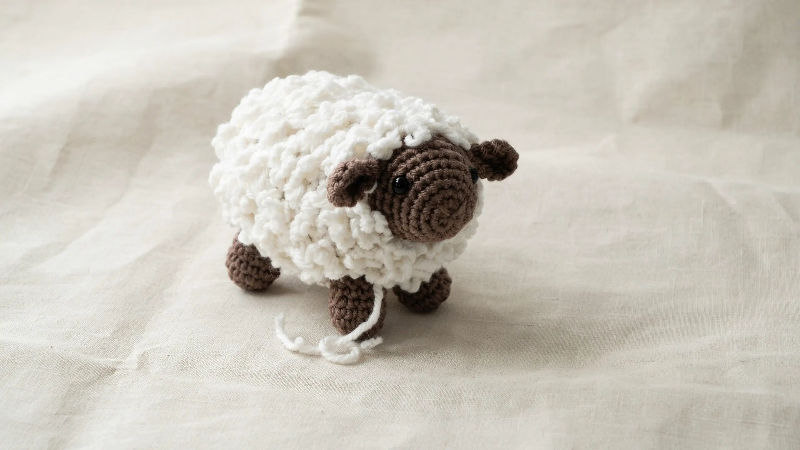 Crochet sheep with textured wool body and darker head and legs centered