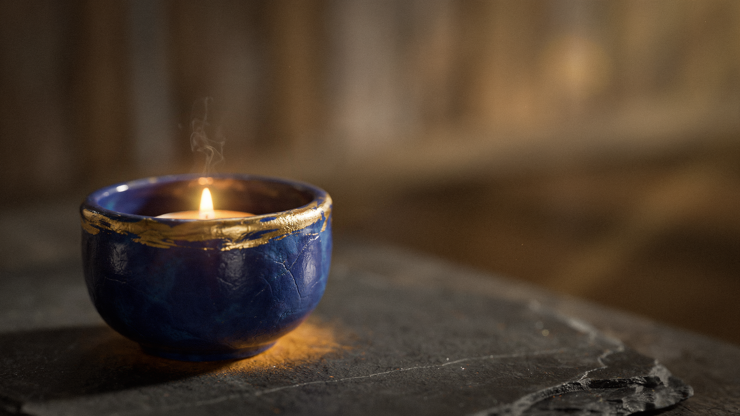 Handmade clay candle holder shaped cylindrical base designed for tea light candle, featuring textured exterior surface and smooth interior seating space