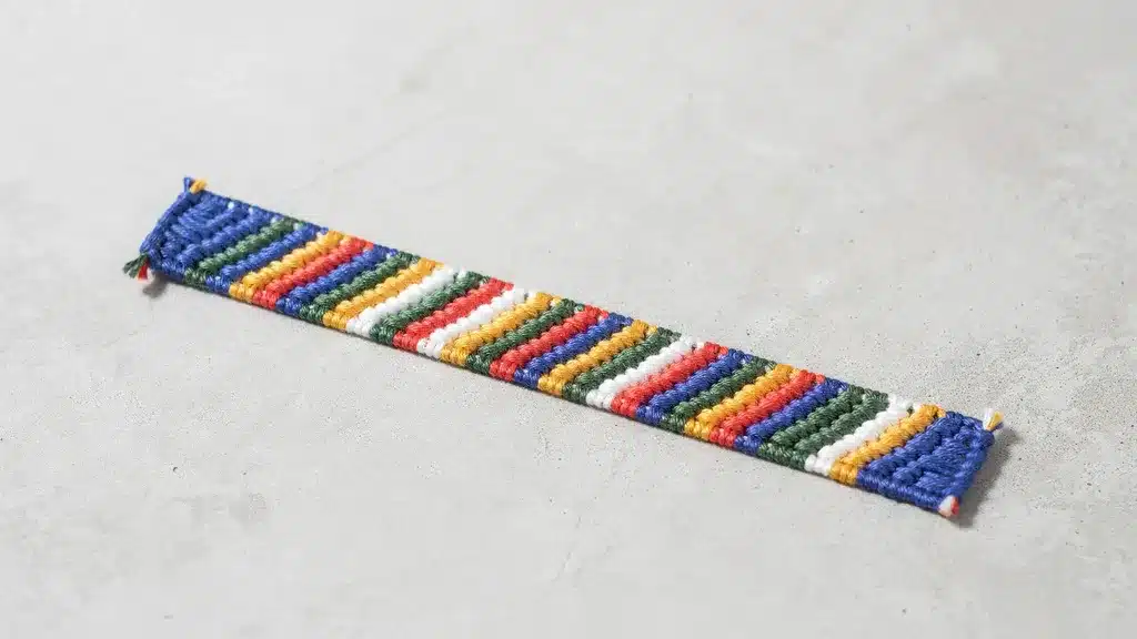 Friendship bracelet featuring colorful diagonal stripes on a simple gray background.