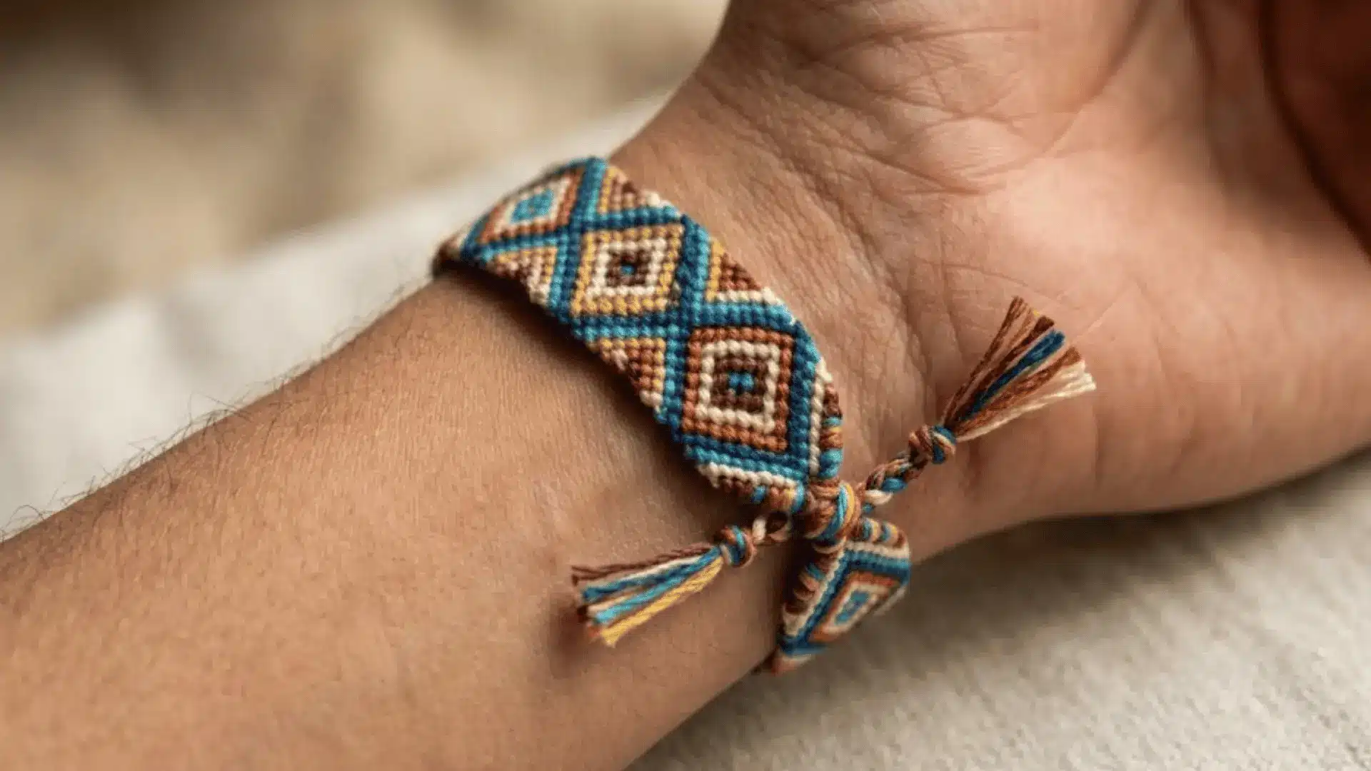 Diamond friendship bracelet with repeating geometric embroidery floss pattern.