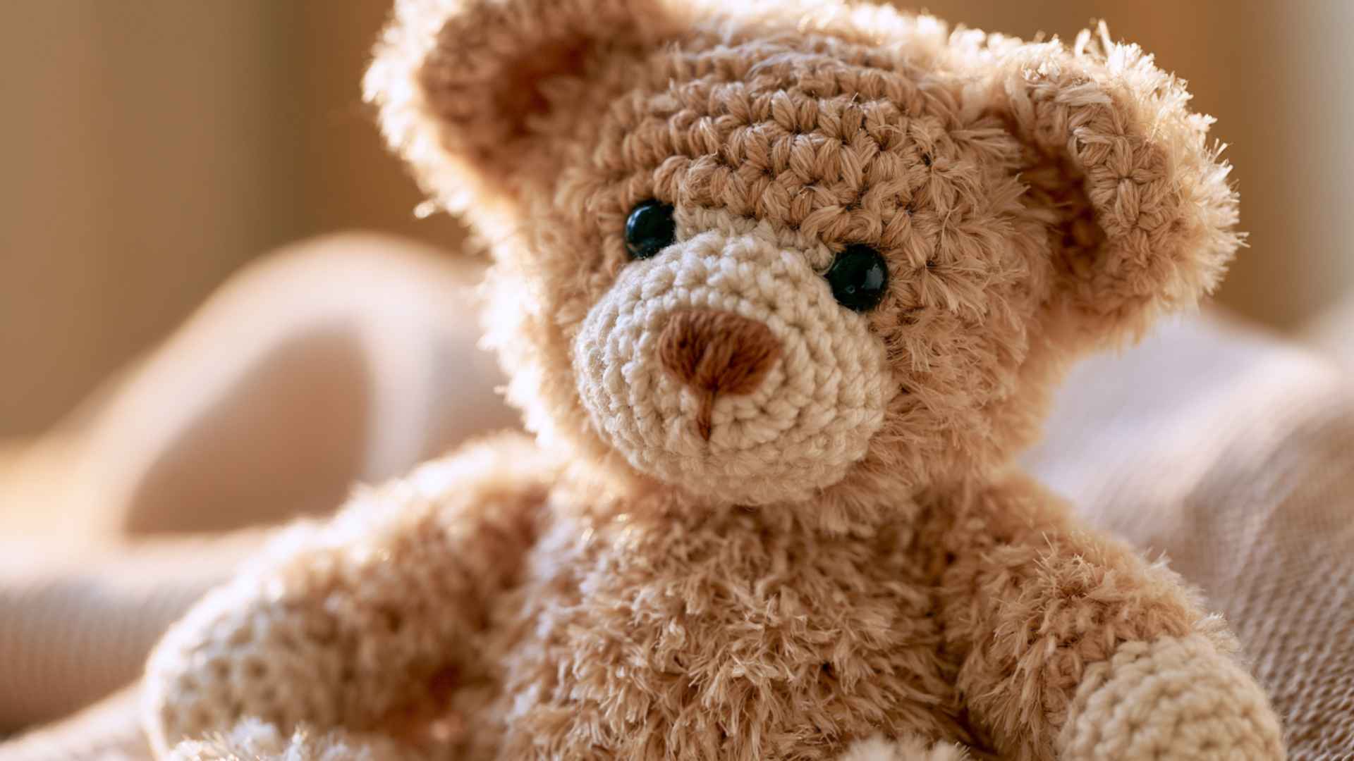 Fluffy crochet bear amigurumi with brushed yarn fur texture showing advanced plush finishing technique on neutral background