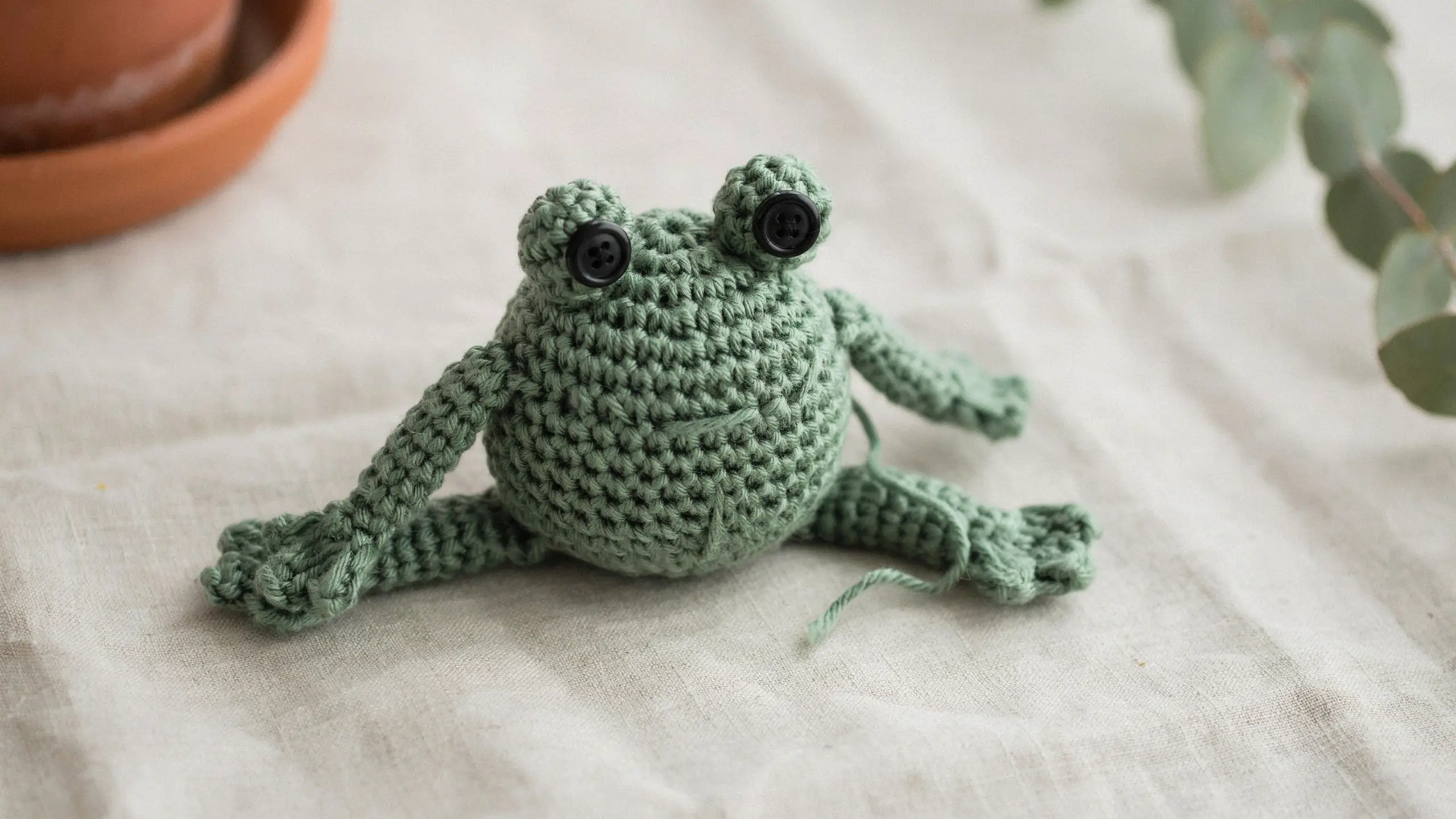 Green crochet frog with top-set eyes centered