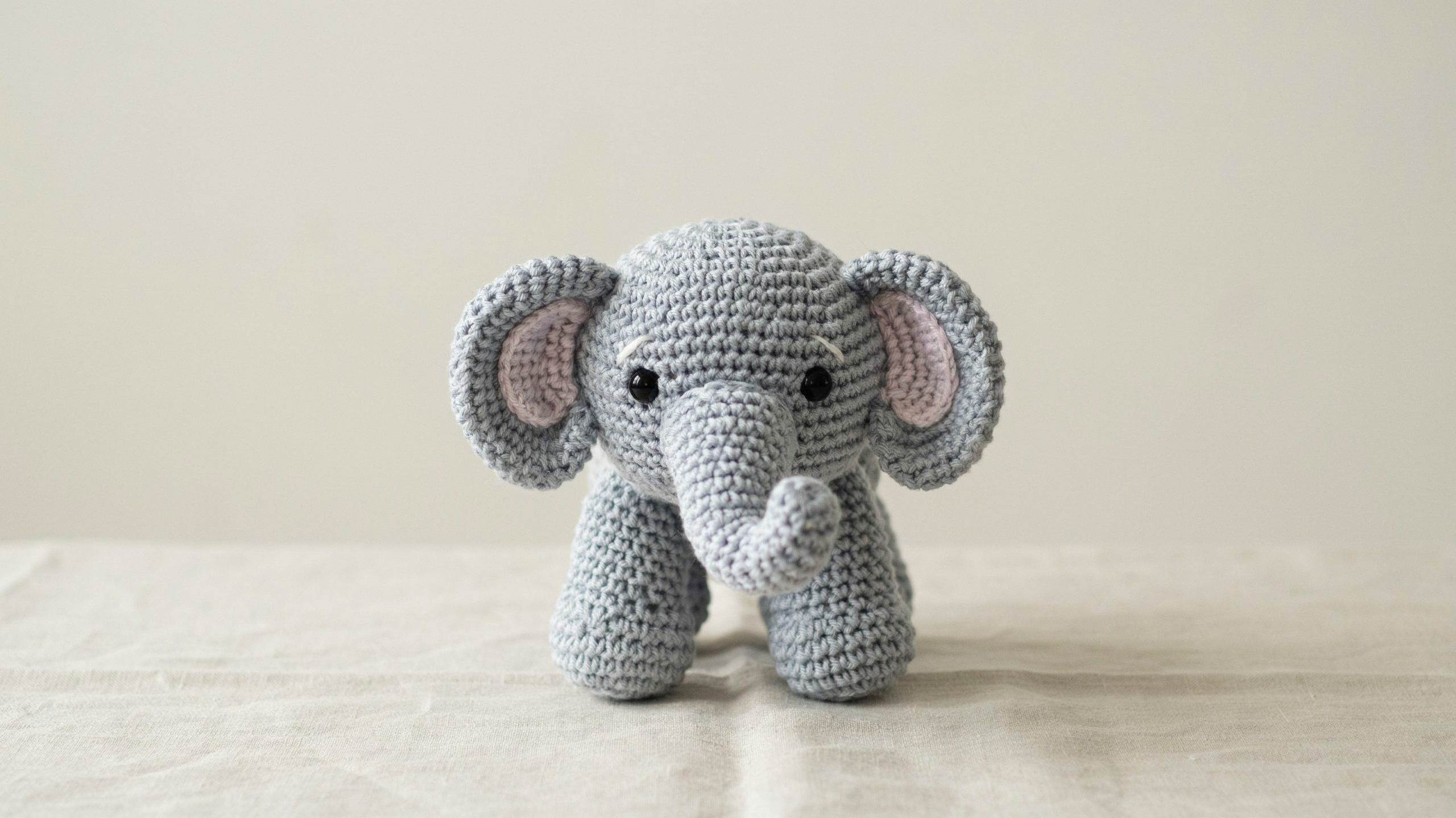 Grey crochet elephant with floppy ears and short trunk centered
