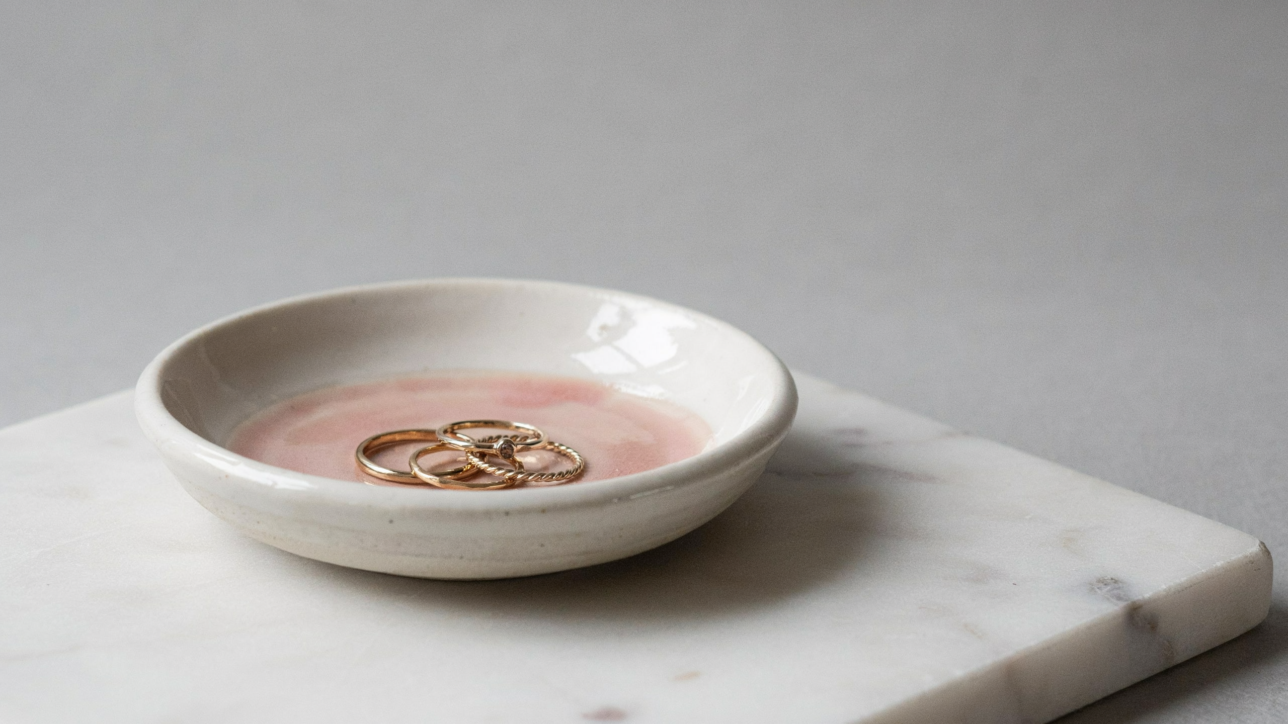 Handmade clay jewelry trinket dish shaped into shallow circular bowl form, designed for holding small accessories, featuring smooth edges and curved interior surface