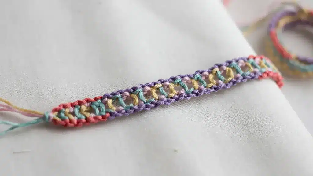 Pastel ladder stitch friendship bracelet with open woven center design.