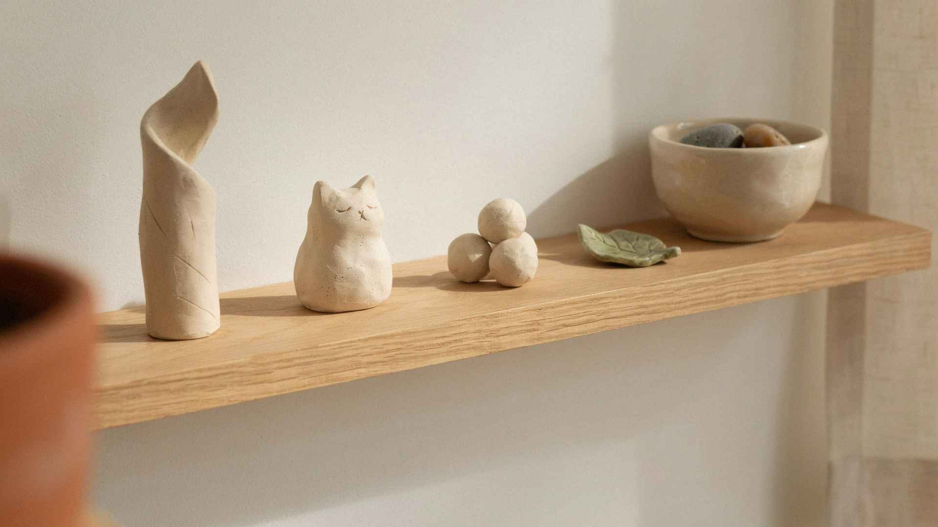 Mini clay figurines on neutral home display shelf