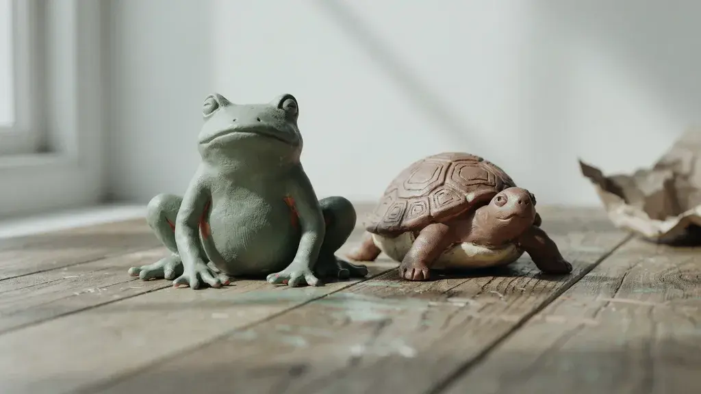 Handmade clay frog and turtle figurines with simple shapes and natural matte finish.