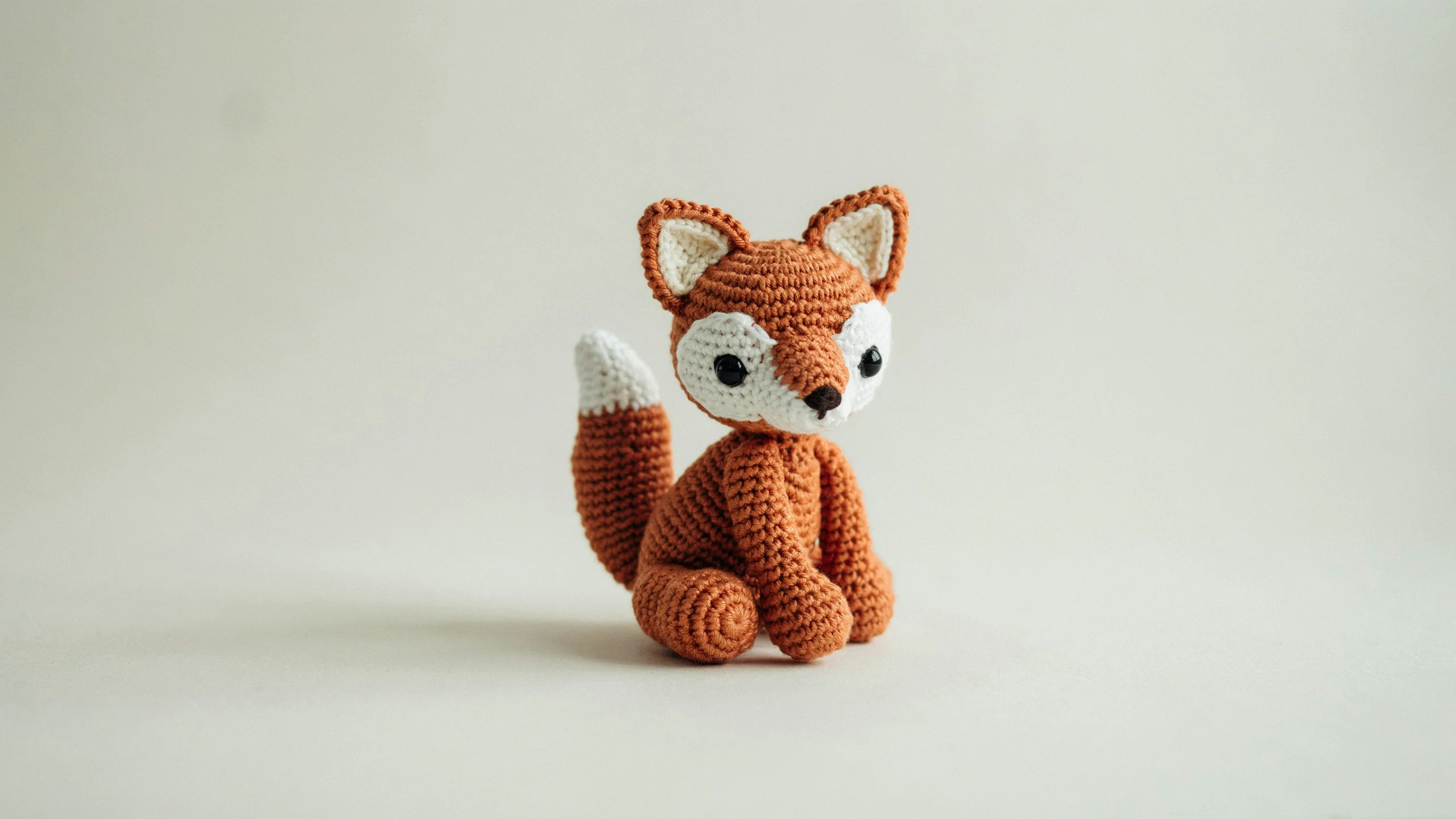 Small crochet fox with pointed snout and curled tail with white tip