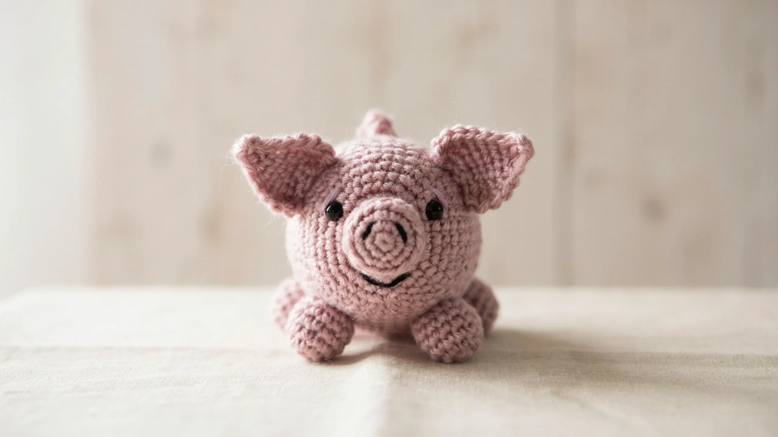 Small crochet pig with flat snout and curled tail
