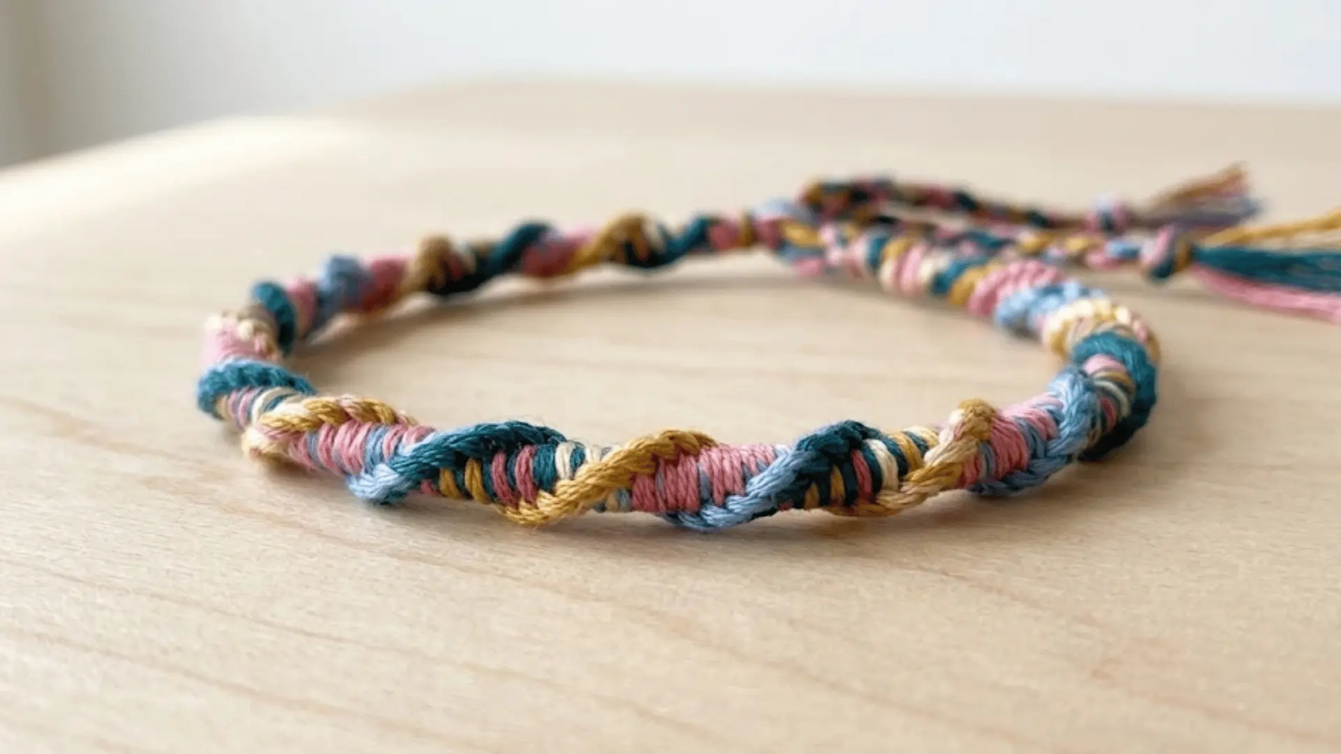 Colorful spiral staircase friendship bracelet with a twisted rope design.