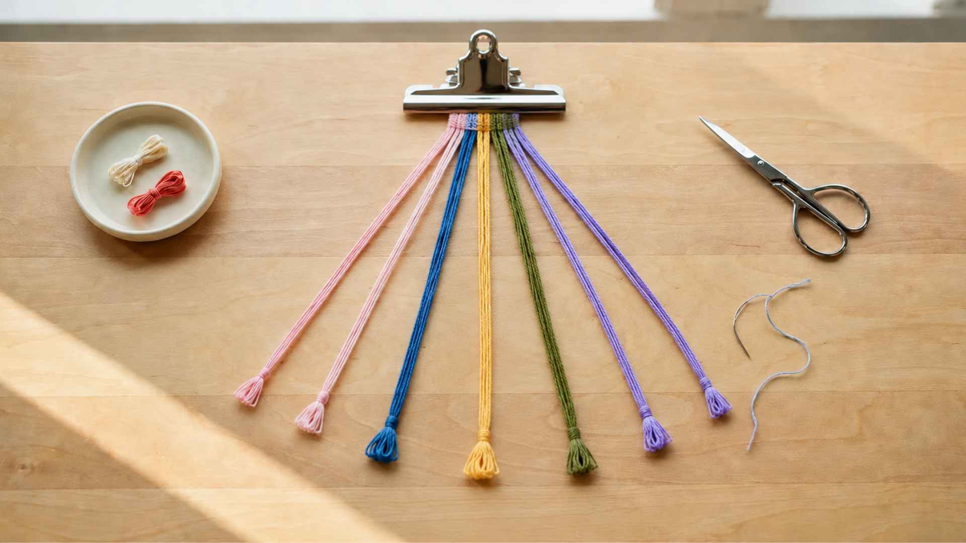 Embroidery floss secured to a clipboard and spread out for friendship bracelet knotting