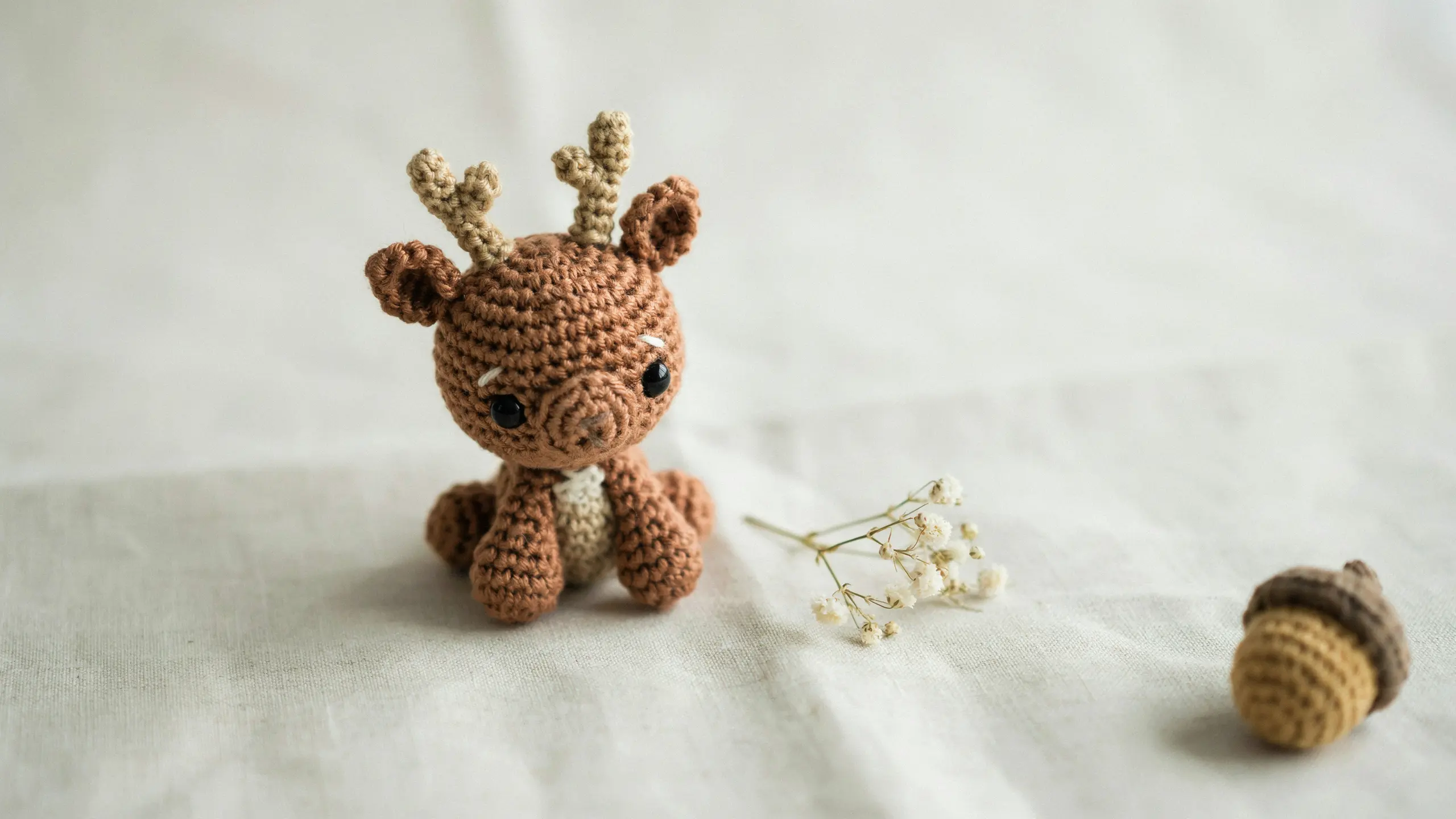 Tiny crochet deer with small antlers and soft face shaping