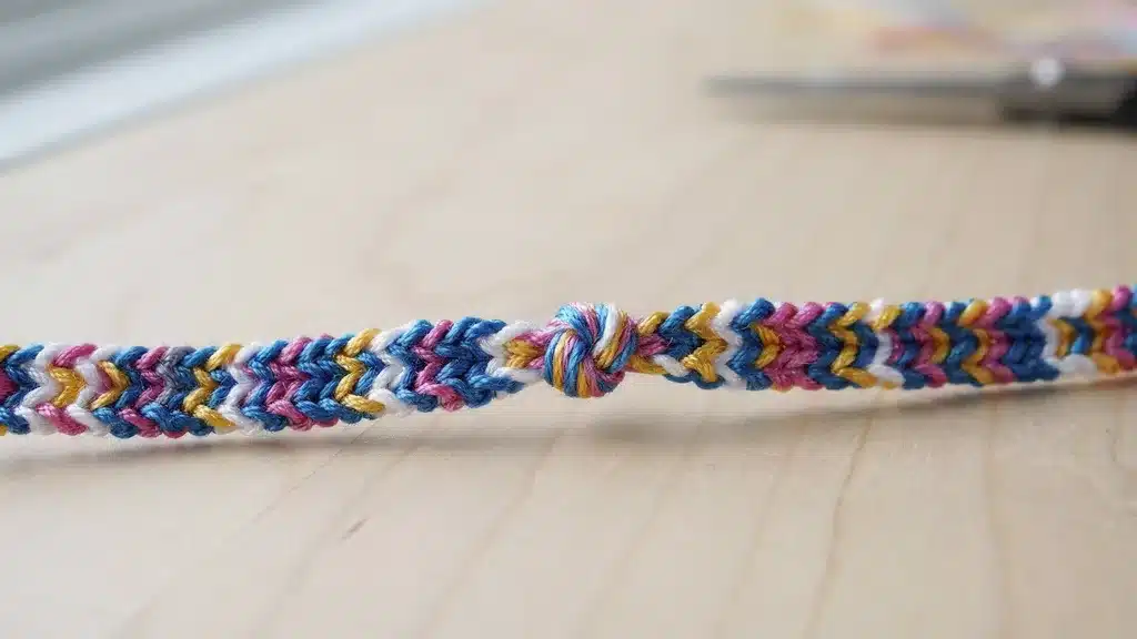 Friendship bracelet finished with a twisted knot closure, showing colorful woven strands and secure fastening.