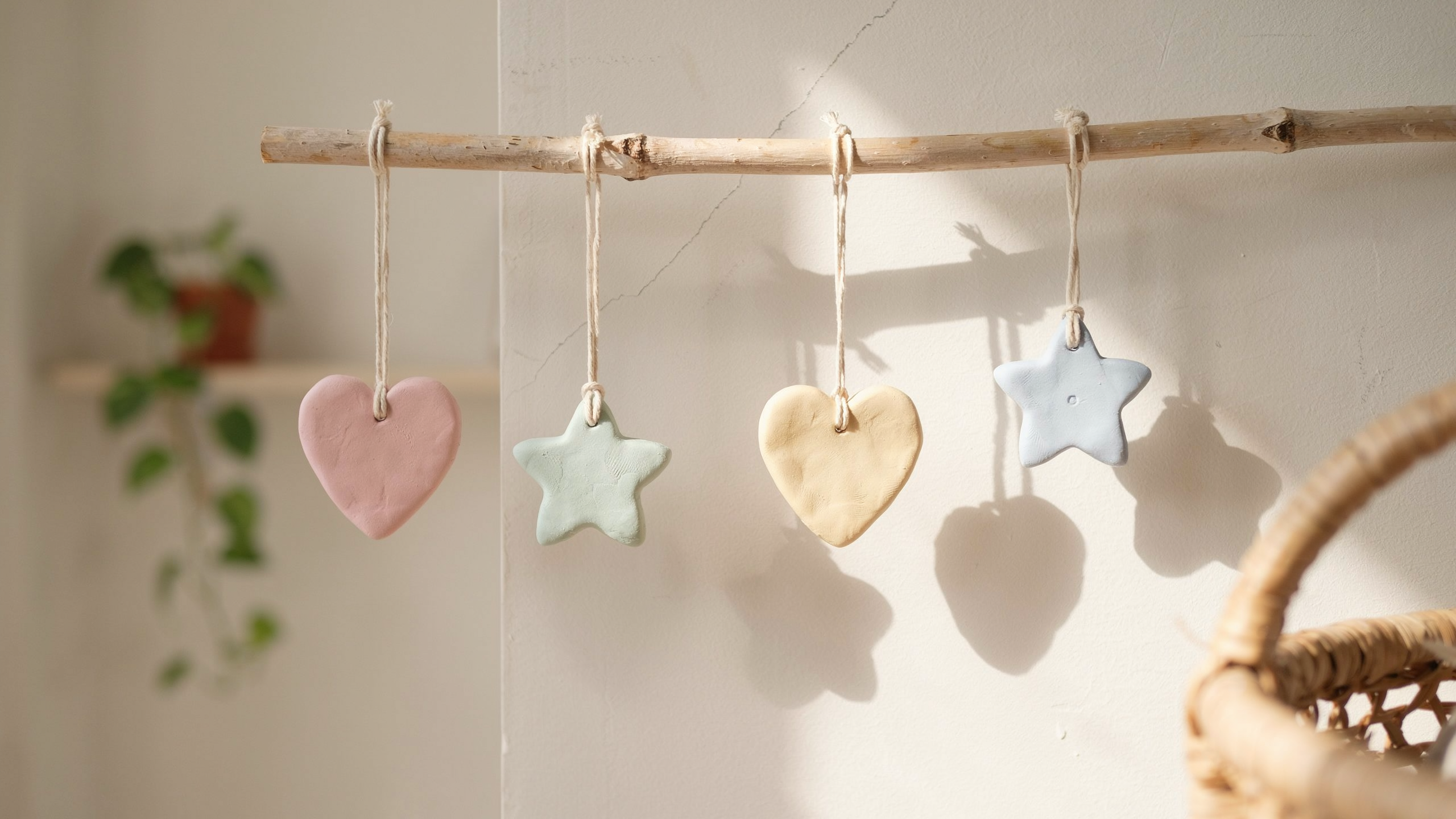Handmade clay wall hanging charms shaped into small decorative pieces with holes for stringing, designed for room decoration and lightweight display arrangement.