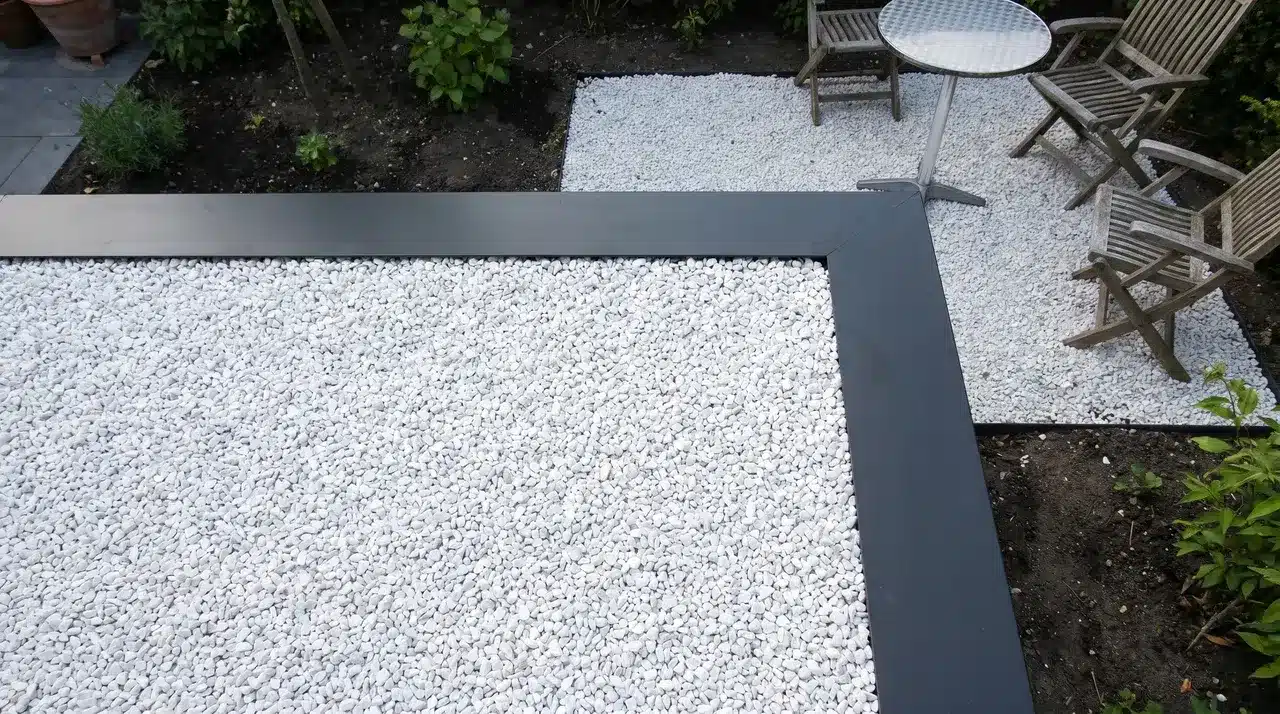 White quartz gravel patio surface contained by dark metal edging viewed from above