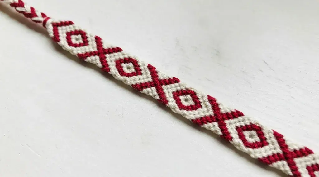X and O friendship bracelet with repeating letter-inspired pattern.
