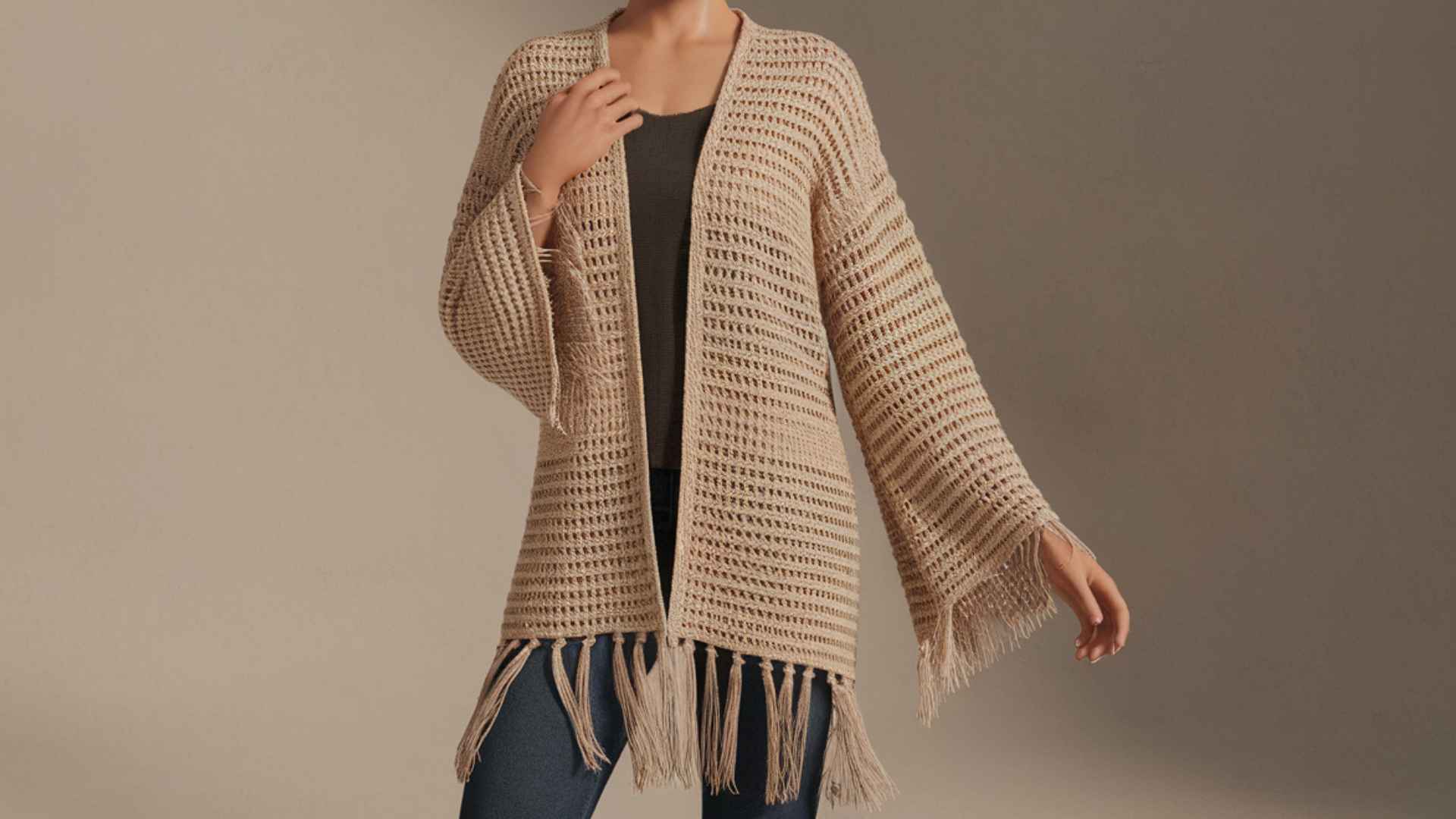 Waist-up model wearing a boho crochet cardigan with fringe cuffs and hem.