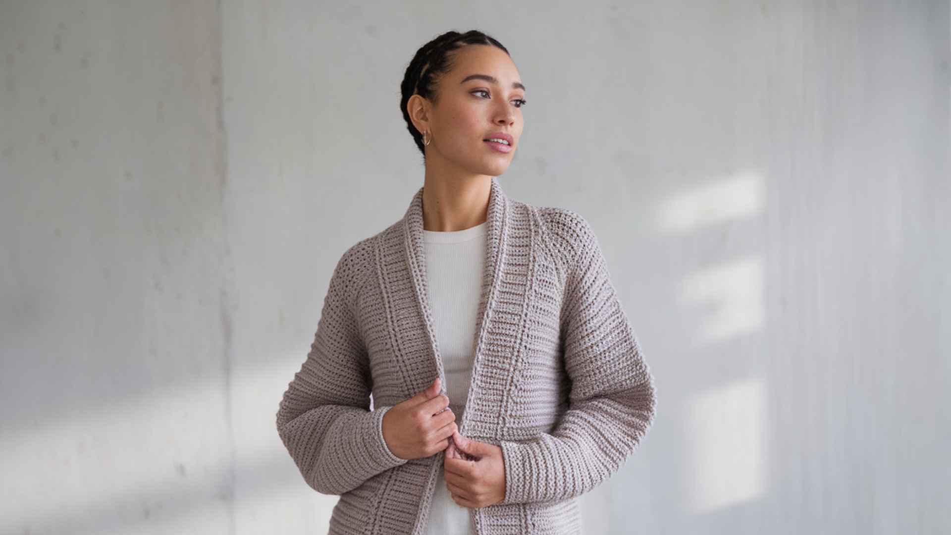 Waist-up model wearing a simple half double crochet cardigan with clean beginner-friendly texture.